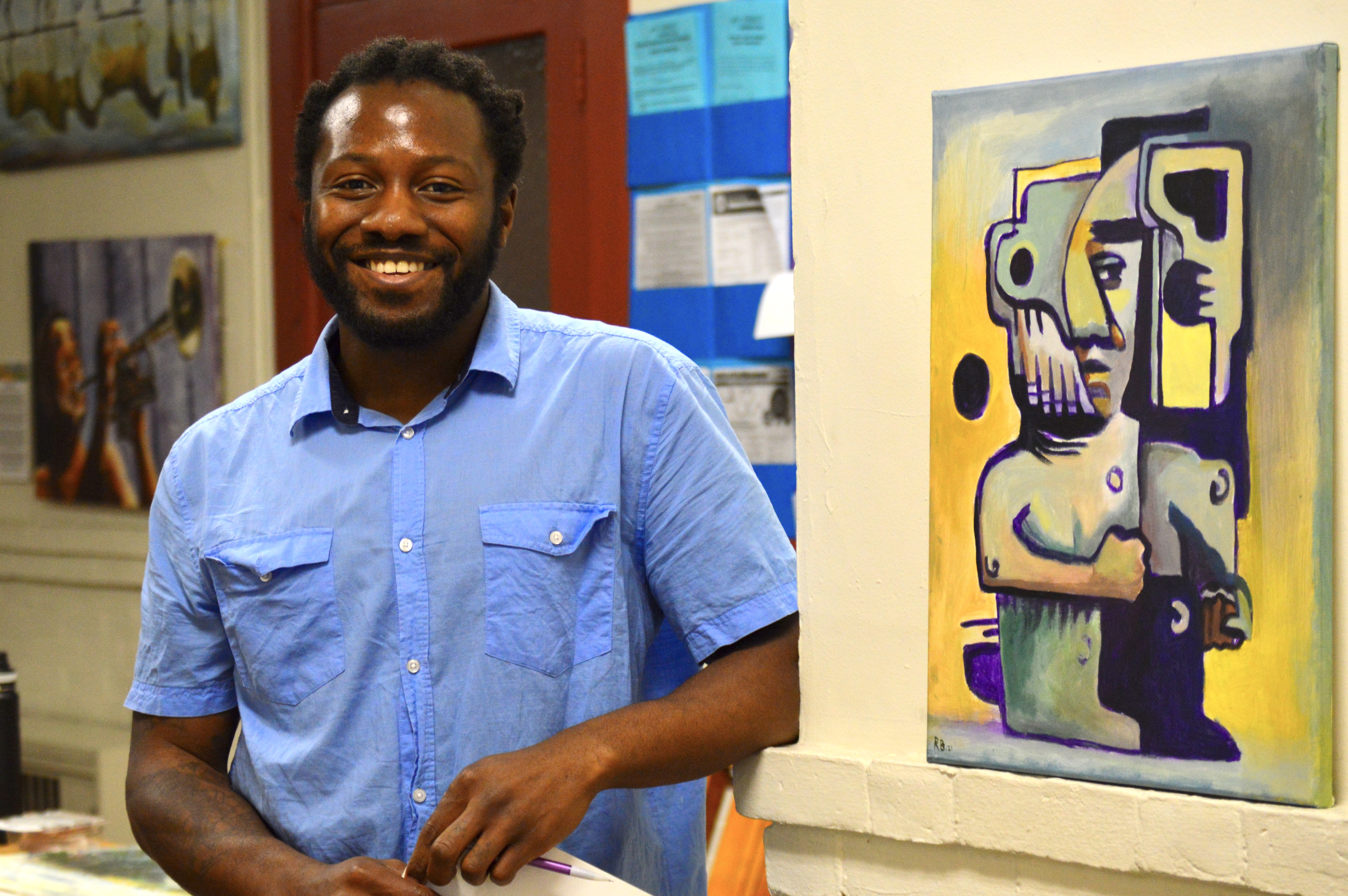 Artist Roxcell Bartholomew standing next to his artwork during the first show in 2023.
