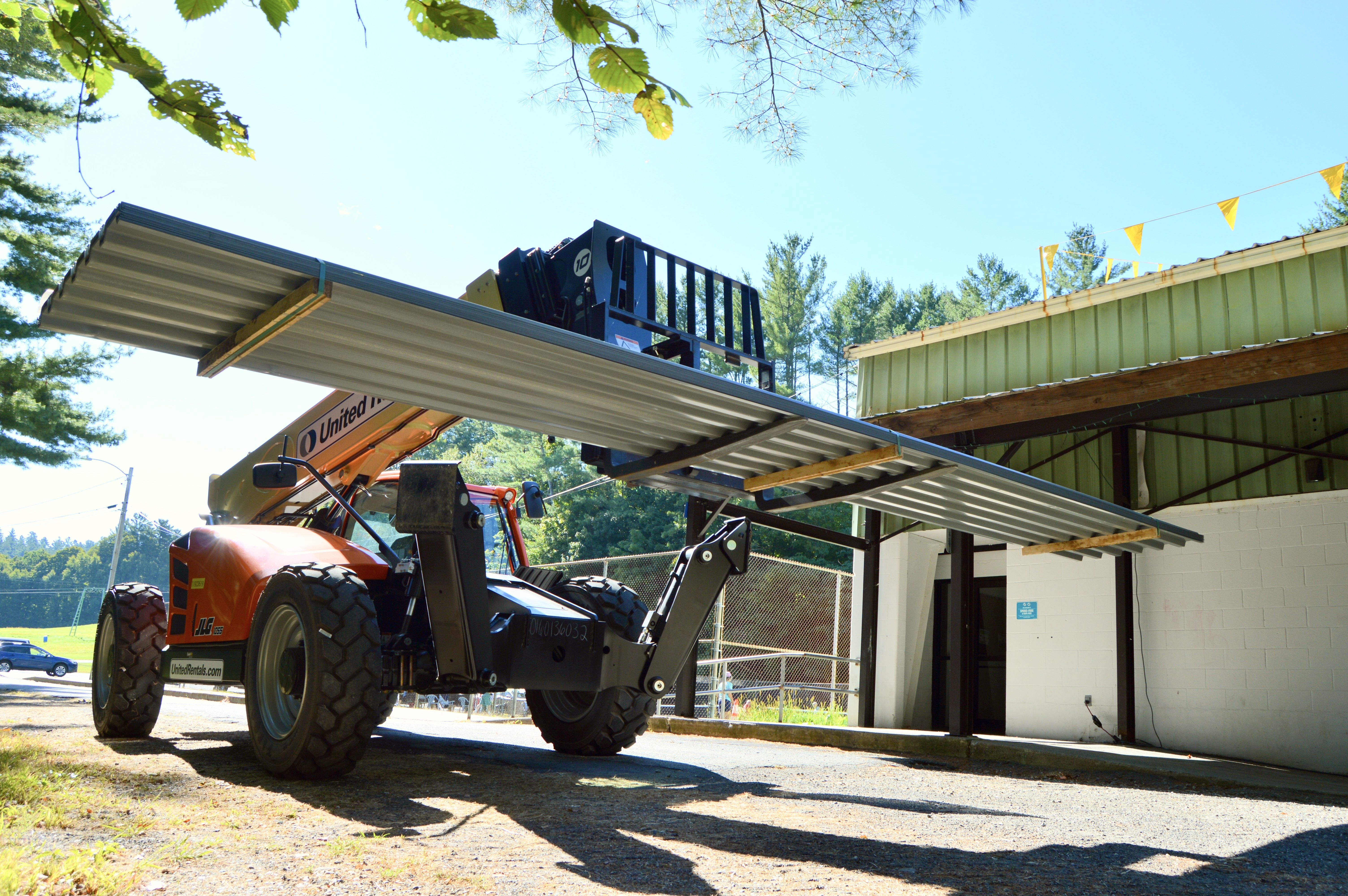 A photo of a construction vehicle transporting a panel to the roof of the skating facility at Living Memorial Park.